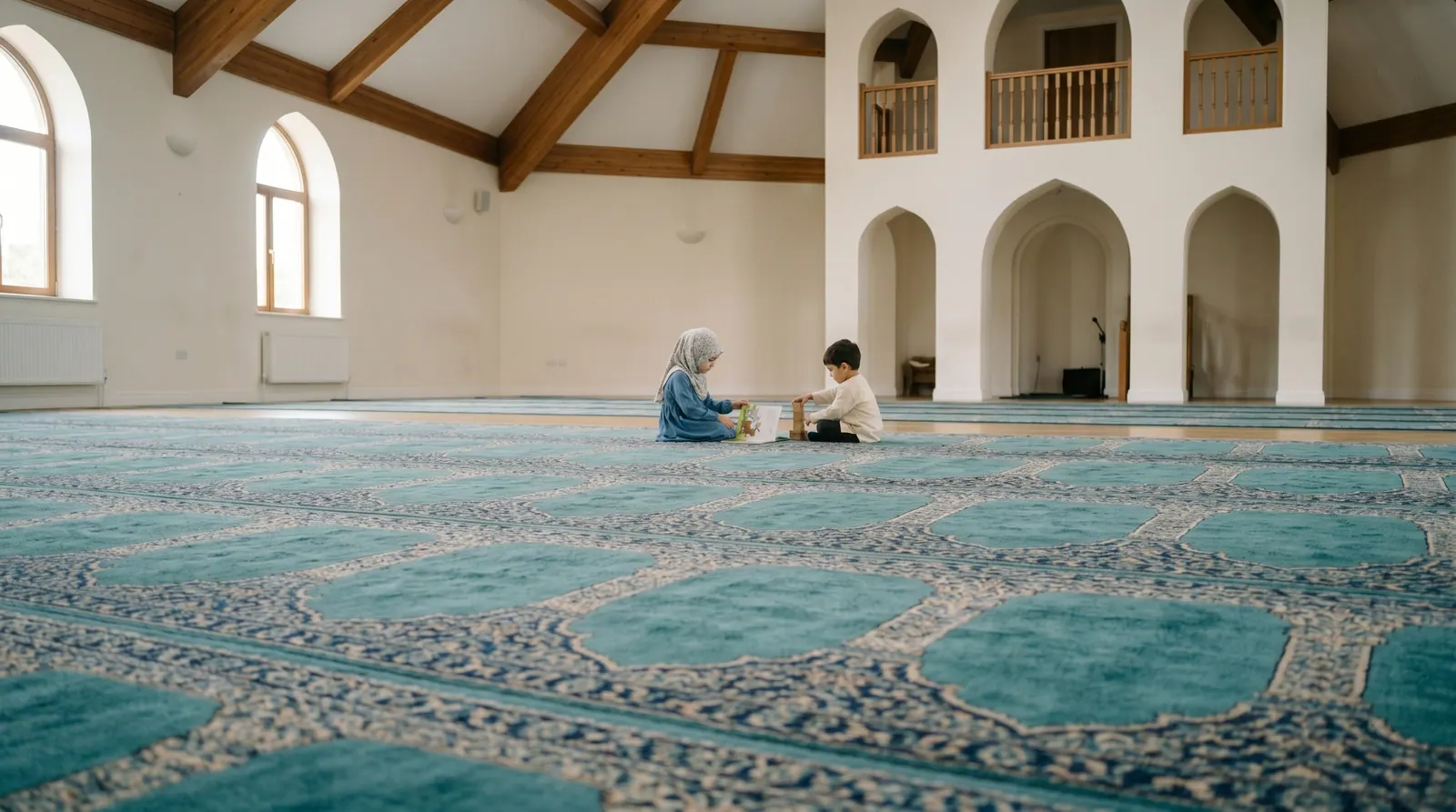 Twee kinderen spelen rustig op het gebedstapijt in de lichte, ruime gebedszaal